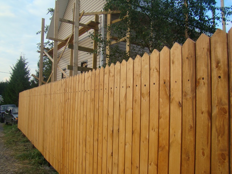 Сплошной забор для дачи из деревянного штакетника елочка