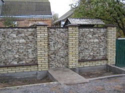 Комбинированный каменный забор с кирпичными столбами